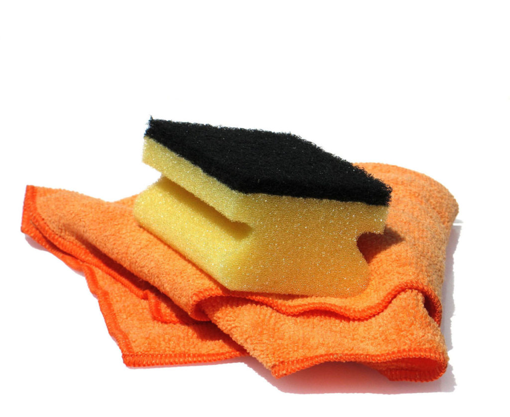A sponge and rag representing cleaning supplies for guests needing Vacation Rental Supplies
