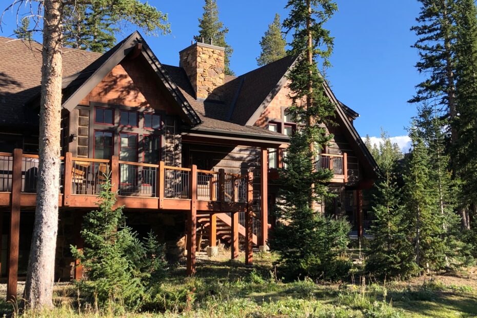 Beautiful mountain vacation rental home in Breckenridge, Colorado, surrounded by pine trees and bathed in summer sunlight—an ideal example of exterior upkeep during summer maintenance for vacation rentals.