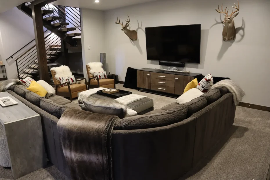 Cozy, professionally cleaned living room in a Summit County vacation rental featuring a large sectional sofa, modern decor, and mounted flat-screen TV—ideal for winter guests.